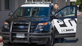officer stands with marked Police car door open