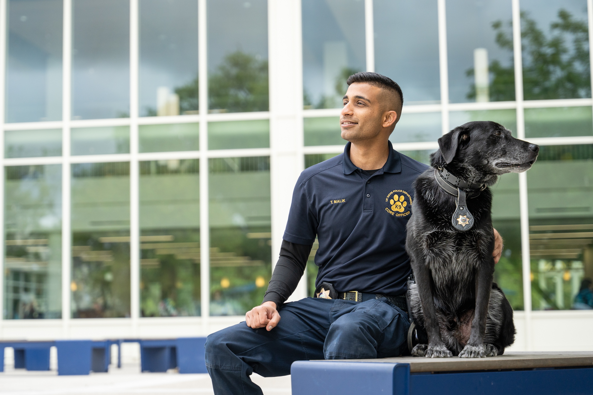 Officer Malik sitting with K-9 Charlie