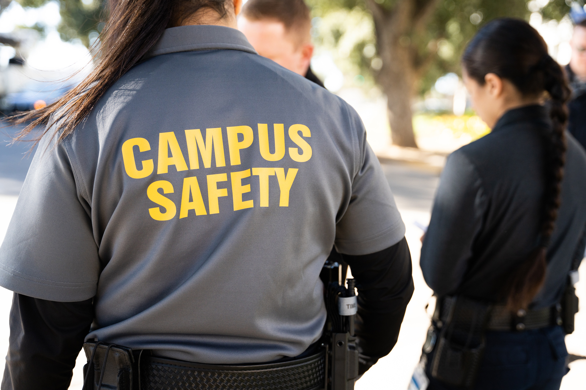 Campus Safety Specialist with her back to the camera, showing the back of the uniform shirt, labeled "Campus Safety"