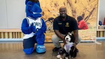 CORE Officer Joe Connors with K-9 puppy Leia posing with Gunrock.