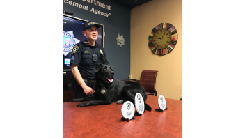 Officer Kwong with K9 Charlie and the awards he won.