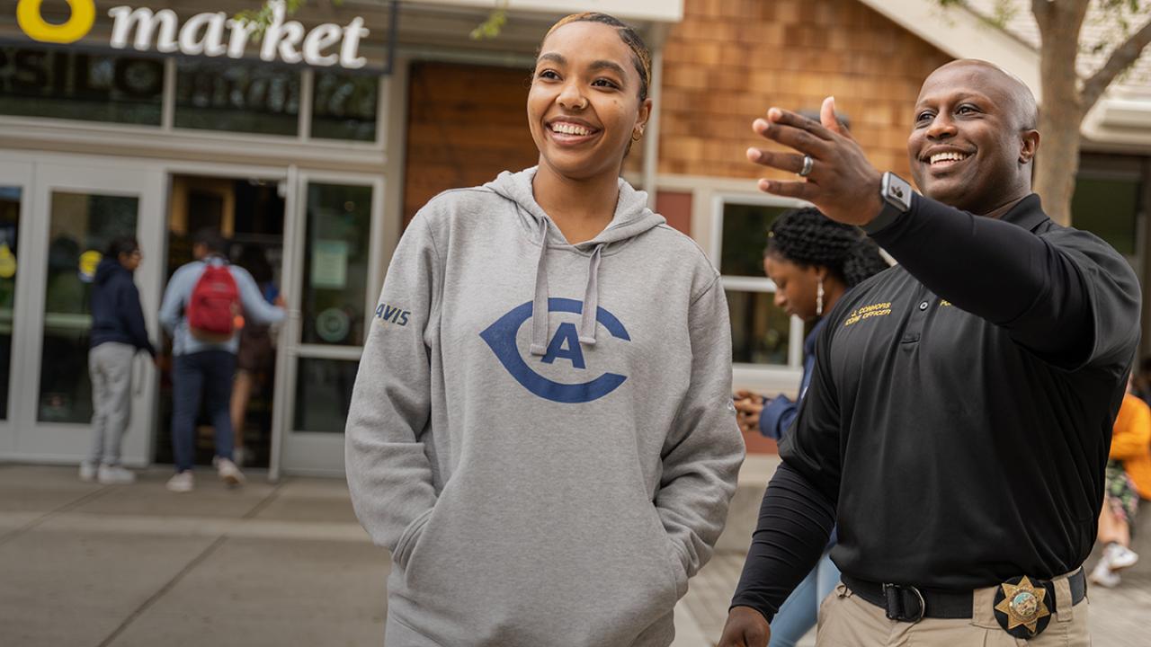 CORE officer Joe Connors laughing with student on campus in front of the Silo.