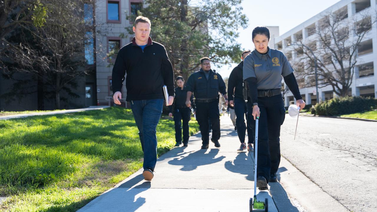 Campus Safety Specialists walking around campus, using a roller tape