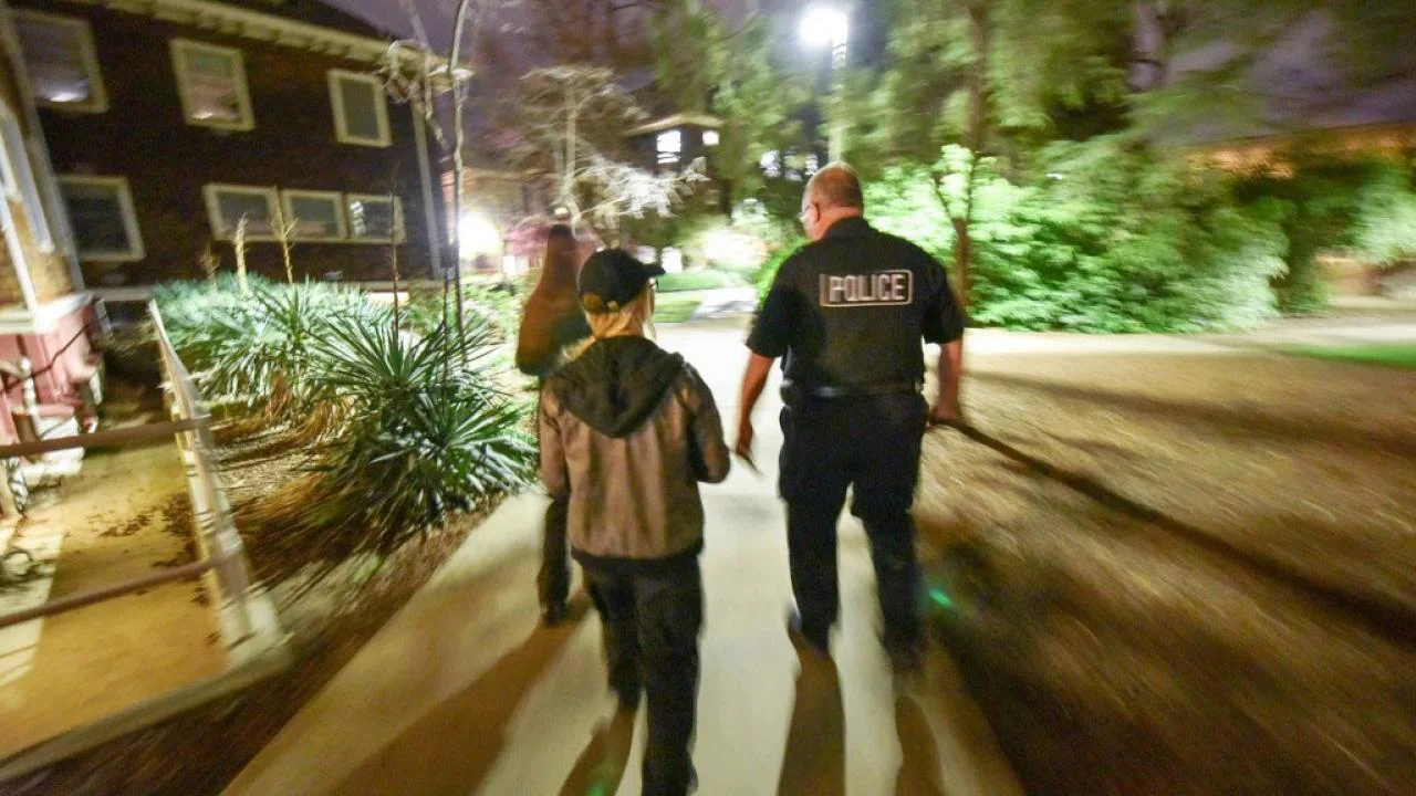 Three people, including a UC Davis police officer participate in a lighting walk
