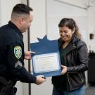 beaming student accepts academy certifiate from UC Davis police officer