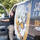 Aggie host smiling from the door of a Safe Ride van