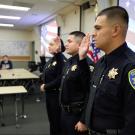 At right, UC Davis police officer Ernesto Moron repeats an oath along with fellow officers David Barilles and Daniella Flores at their swearing-in ceremony at the UC Davis Police department on Dec. 22, 2023. Photo by Fred Greaves for CalMatters.