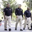 CORE officers and k9s walk through campus with Shields Library in the background.
