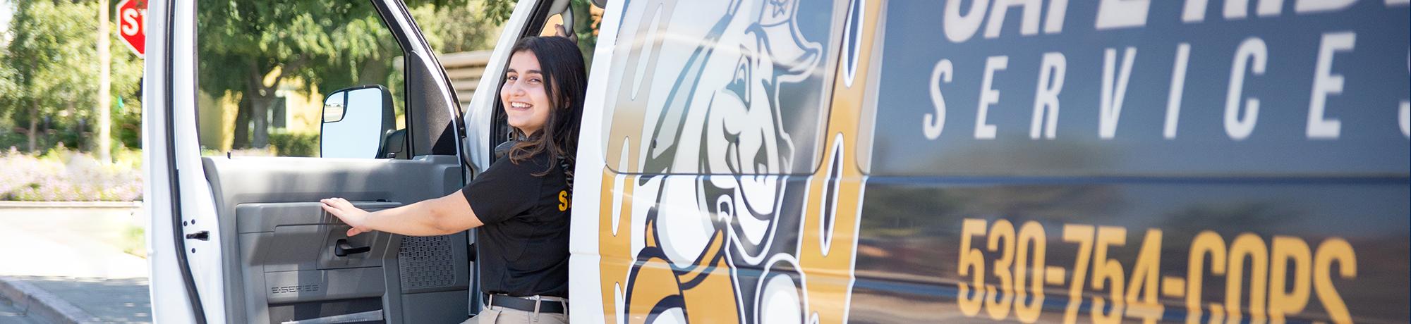 Aggie Host smiles from Safe Ride van