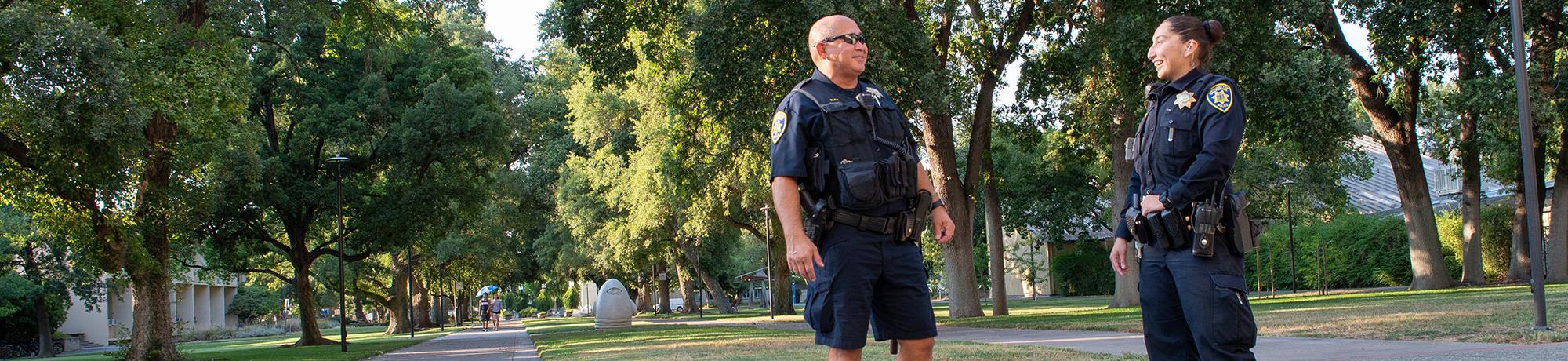 Police officers talk and laugh near Mrak Hall at UC Davis Campus