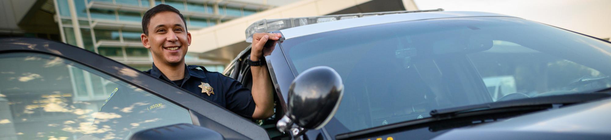 Police officer smiling and stepping out of vehicle