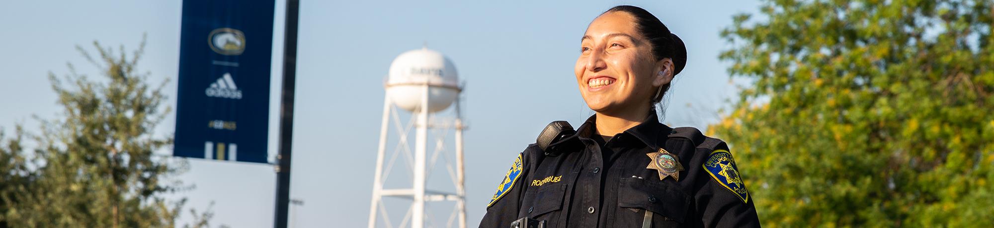 Officer smiles with UC Davis water tower in the background