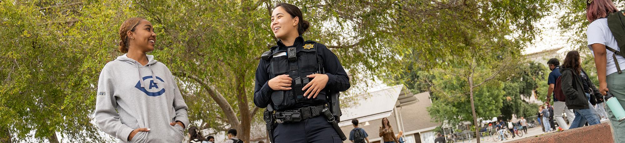 UC Davis Police Officer talking to a student outside of the Silo on Campus.