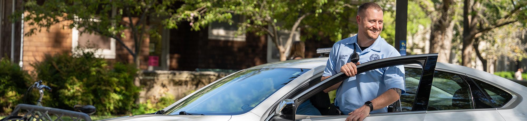 UC Davis Security officer smiling and exiting vehicle near the Quad