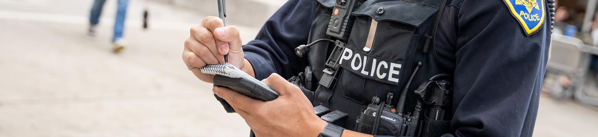 police officer writing something down on a notepad.